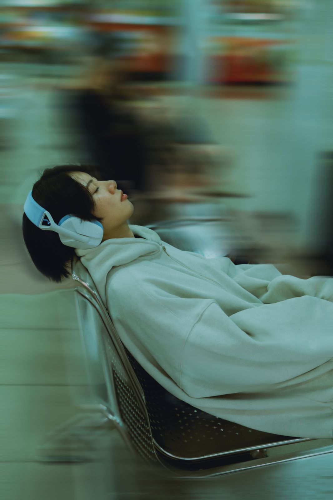 Persona in ascolto con cuffie mentre il movimento intorno rallenta.
